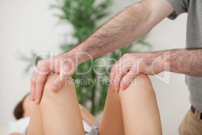 Knees of a patient being held by a doctor