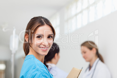 Smiling woman  while standing in a hallway with a patient and a