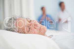 Elderly patient sleeping on a bed next to a doctor