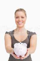 Woman showing a piggy bank