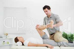 Chiropractor stretching the leg of his patient while holding it