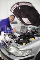 Mechanic repairing a car with a computer