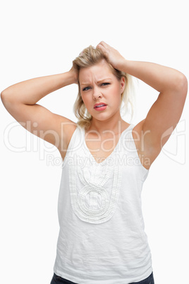 Upset woman frowning while placing her hands on her head
