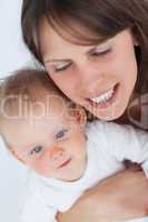 Cheerful mother holding her cute baby