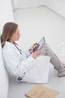 Doctor sitting on the floor holding a digital tablet pc