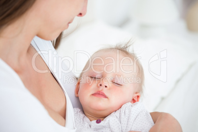 Baby falling asleep in the arms of her mother