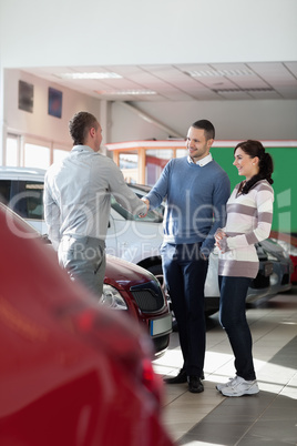 Car dealer shaking hand with a man