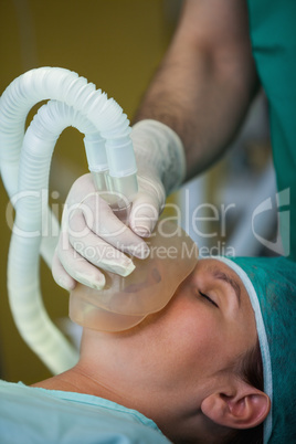 Surgeon placing a mask in the face of a patient