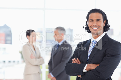 Executive crossing his arms in front of two business people