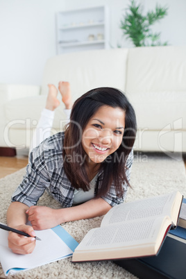 Smiling woman with a book and a notebook