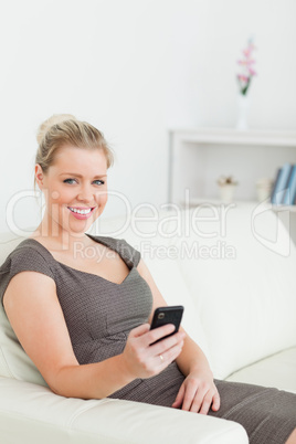 Woman sitting on a sofa using her phone