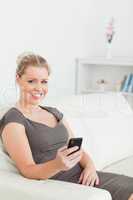Woman sitting on a sofa using her phone