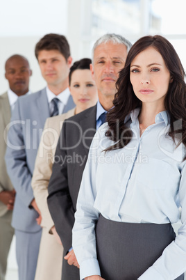 Serious executive woman standing upright in front of her busines