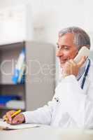 Doctor calling while holding a pen