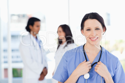 Smiling medical intern with her hair tied back standing in front