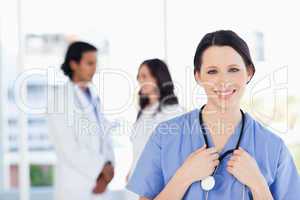 Smiling medical intern with her hair tied back standing in front