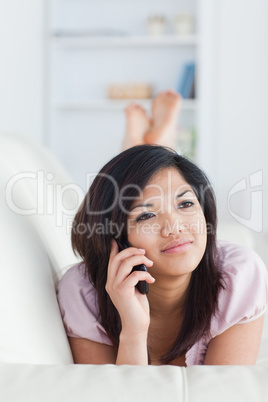Woman relaxing on a couch while phoning
