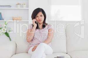 Woman holding a phone and sitting on a couch