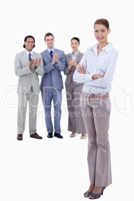 Woman crossing her arms with business people applauding while wa