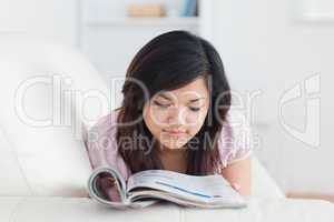 Woman lying on a couch while reading