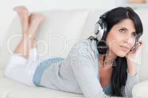 Woman lying on a couch with headphones on