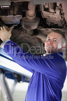 Smiling mechanic repairing a car