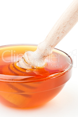 Close up of a honey bowl with a honey dipper