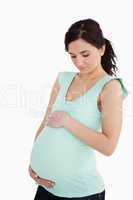 Young pregnant woman looking at her belly