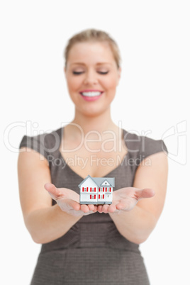 Woman looking a little model house on her hands