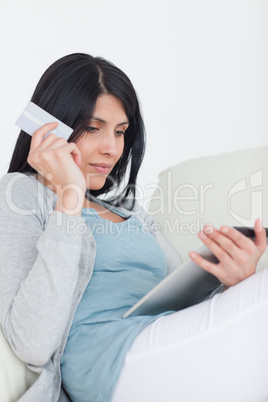 Woman holding a credit card and a tablet