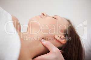 Close-up of physiotherapist pressing his thumb on the neck of a