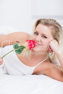 Young woman smelling a pink rose