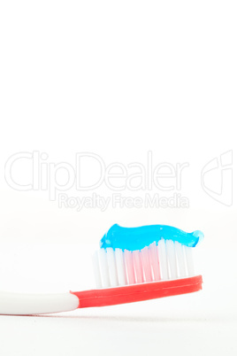 Blue toothpaste on a red toothbrush