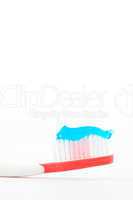 Blue toothpaste on a red toothbrush