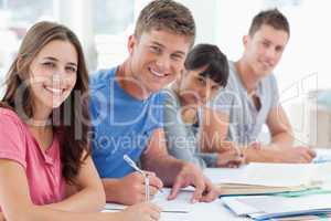 Side view of four students looking at the camera and smiling