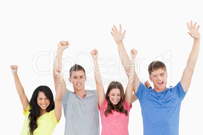 People celebrating with their hands in the air and looking at th