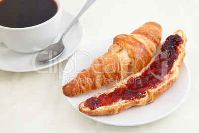 Croissant next to a coffee cup