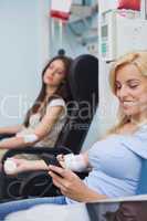 Patient receiving a transfusion using her mobile phone