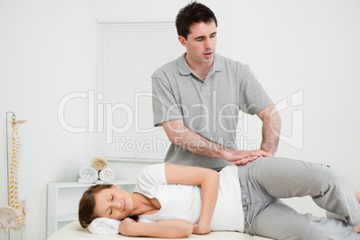 Doctor pressing his hands on the hip of his patient
