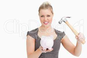 Woman want break a piggy bank with a hammer