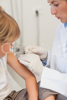 Doctor injecting liquid in a child arm