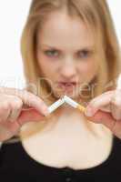 Young woman breaking a cigarette