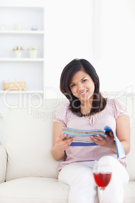 Woman holding a magazine and sitting on a couch