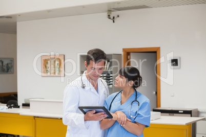 Doctor holding a tablet computer next to a nurse