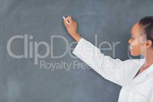 Black teacher writing on a blackboard