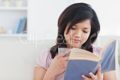 Woman reading a book while holding a cup