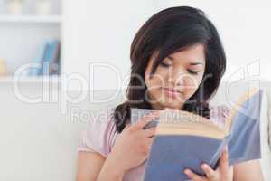 Woman reading a book while holding a cup