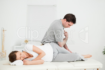 Chiropractor massaging the thigh of his patient while using his