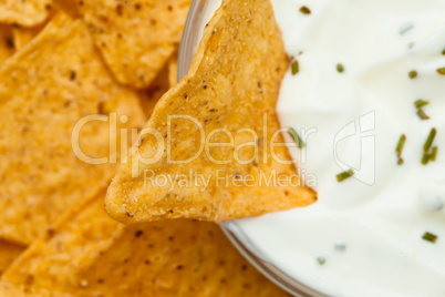 Close up of a nacho dipped into a bowl of dip