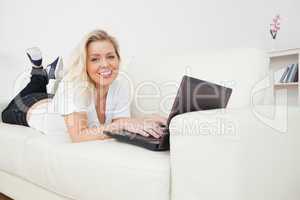 Woman smiling while using a laptop